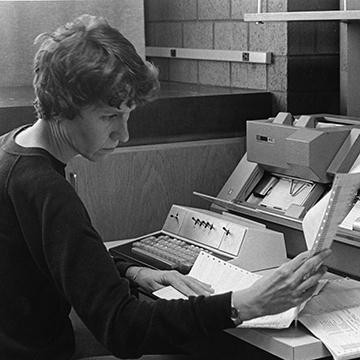 A woman in the business office looks over paperwork.